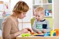 Child and woman play colorful clay toy in nursery Royalty Free Stock Photo