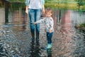 Child and woman standing in the puddle