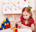 Child with wood block in play room. Royalty Free Stock Photo