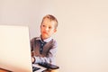 Child working with his computer in his business, concentrated typing to succeed, funny image
