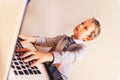 Child working with his computer in his business, concentrated typing to succeed, funny image