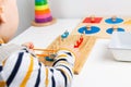 Child works with Montessori material for fine motor skills, sensory play. Playing children
