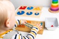 Child works with Montessori material for fine motor skills, sensory play. Playing children