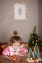 Child writes letter to Santa Claus at home. little girl draws with crayons on background of Christmas devoration Royalty Free Stock Photo