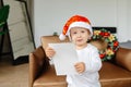 A child writes a letter to Santa Claus. The child& x27;s hands, a sheet of paper, Malish is holding the letter. The