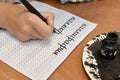 The child writes the word  `calligraphy` with a fountain pen. The Russian text - a calligraphy Royalty Free Stock Photo