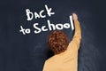 Child writing boy Back to school text on chalkboard background Royalty Free Stock Photo