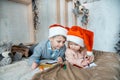 Child writing letter to Santa Claus letter in red hat. Family on Christmas. Bright living room with komin on New Year`s Eve.Cozy Royalty Free Stock Photo