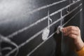 Child writing music notes on blackboard