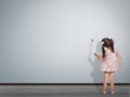 Child writing with paint brush on empty wall, back view Royalty Free Stock Photo