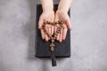 Child& x27;s hands holding the wooden cross and beads th in the shape of a heart on the biblia Royalty Free Stock Photo