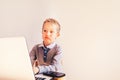 Child 5 years old working on a laptop with an angry face when business failing, humor image