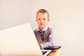 Child 5 years old working on a laptop with an angry face when business failing, humor image