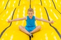 Child on yellow playground trampoline. Kids jump in inflatable bounce castle on kindergarten birthday party. Activity and play cen