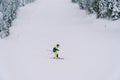 Child in a yellow ski suit skis down a mountain slope, leaning to the side Royalty Free Stock Photo