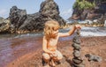 Child with zen stones on sea beach, meditation, spa and harmony. Calm balance concept. Kids play on the beach. Royalty Free Stock Photo