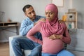 Childbirth Concept. Pregnant Black Muslim Woman Feeling Abdomenal Pain At Home