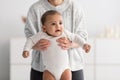 Young babysitter nanny playing with adorable black infant