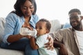 Happy African American mom feeding child from bottle Royalty Free Stock Photo