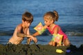 Childen building sand castle out of black volcanic cyprus sand