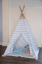 Childen`s room corner with a beautifully decorated play tipi tent and a pillows.Cozy play tent for kids as element of Royalty Free Stock Photo