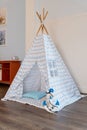 Childen`s room corner with a beautifully decorated play tipi tent and a pillows.Cozy play tent for kids as element of Royalty Free Stock Photo