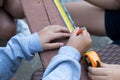 The childens is repairing wooden with a pencil and tape measure Royalty Free Stock Photo