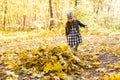 Childhood, autumn, people concept - child girl playing in autumn leaves