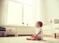 Happy baby boy or girl sitting on floor at home Royalty Free Stock Photo