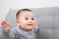 Childhood, babyhood and people concept - happy little baby girl sitting on sofa at home