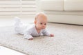 Childhood, babyhood and people concept - little baby boy or girl crawling on floor at home Royalty Free Stock Photo