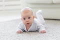 Childhood, babyhood and people concept - little baby boy or girl crawling on floor at home Royalty Free Stock Photo