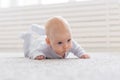 Childhood, babyhood and people concept - little baby boy or girl crawling on floor at home Royalty Free Stock Photo