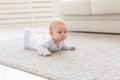 Childhood, babyhood and people concept - little baby boy or girl crawling on floor at home Royalty Free Stock Photo