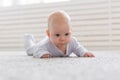 Childhood, babyhood and people concept - little baby boy or girl crawling on floor at home Royalty Free Stock Photo