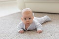 Childhood, babyhood and people concept - little baby boy or girl crawling on floor at home Royalty Free Stock Photo