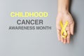 Childhood Cancer Awareness month, hand holding Gold Yellow Ribbon for supporting people living and illness. children Healthcare Royalty Free Stock Photo