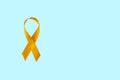 Childhood Cancer Awareness Yellow Ribbon on blue background with copy space