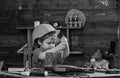 Childhood concept. Kid boy in orange hard hat or helmet, study room background. Boy play as builder or repairer, work Royalty Free Stock Photo