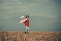 Childhood on countryside. Pilot aviator child with a toy airplane plays on summer nature. Boy with plane on meadow Royalty Free Stock Photo