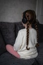 Childhood depression young girl sat quiet alone with autism looking away back turned headphones block out noise causing anxiety