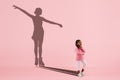 Childhood and dream about big and famous future. Conceptual image with girl and shadow of fit female figure skater on Royalty Free Stock Photo