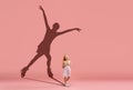 Childhood and dream about big and famous future. Conceptual image with girl and shadow of female figure skater on coral Royalty Free Stock Photo