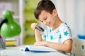 Boy with magnifier reading book at home