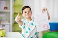 Happy smiling boy holding school test with a grade