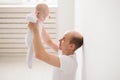 Childhood, family and fatherhood concept - proud bald father holding his newborn baby daughter in the air Royalty Free Stock Photo