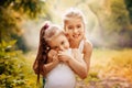 Childhood, family, friendship and people concept - two happy kids sisters hugging outdoors. Royalty Free Stock Photo