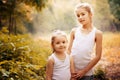 Childhood, family, friendship and people concept - two happy kids sisters hugging outdoors. Royalty Free Stock Photo