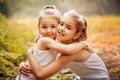 Childhood, family, friendship and people concept - two happy kids sisters hugging outdoors.