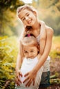 Childhood, family, friendship and people concept - two happy kids sisters hugging outdoors.